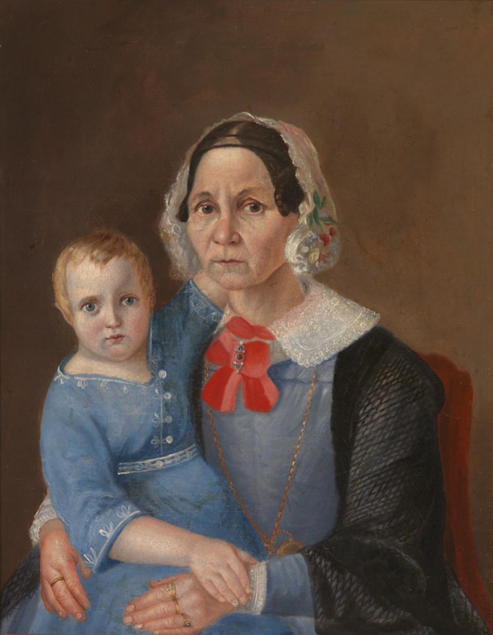 Pagyvenusi moteris su vaiku ant rankų